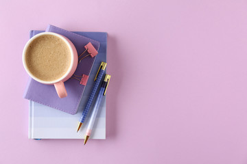 Stylish stationery with cup of coffee on color background