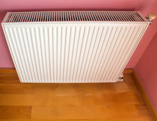 Modern radiator on color wall indoors. Central heating system