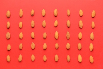 Tasty almond nuts on color background