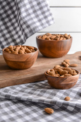 Bowls with tasty almonds on table