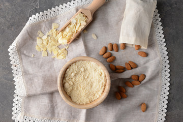 Bowl with tasty almond flour on grey table