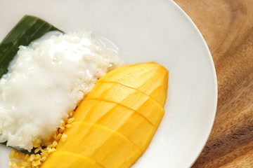 Close up of mango sticky rice on white plate, popular traditional sweet dessert of thailand.