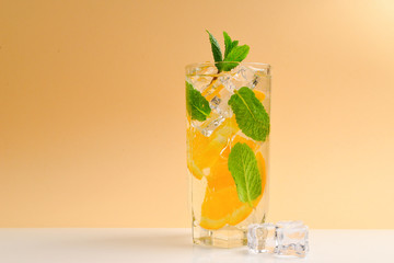 Cocktail with lemon and mint on a beige background. Copy space.