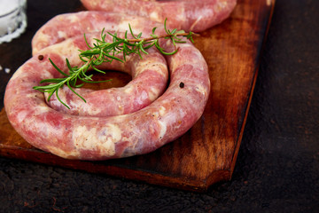 Raw spiral pork sausages with rosemary, salt and peper