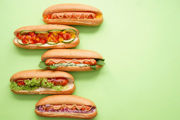 Tasty hot dogs on color background