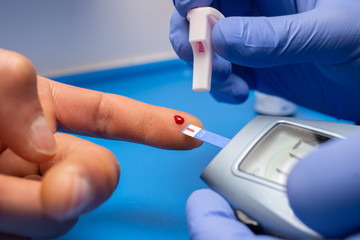 closeup of professional checkhing blood test with digital glucometer