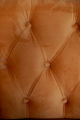 Upholstery orange sofa or chair . Velvet with buttons. Texture