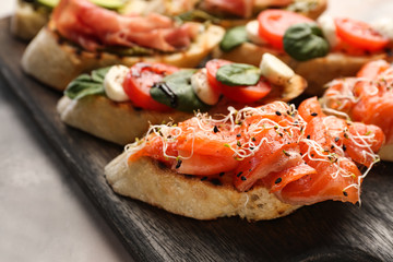 Fresh tasty bruschettas on wooden board, closeup