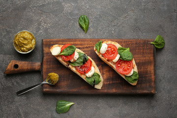 Wooden board with fresh tasty bruschettas on grey background