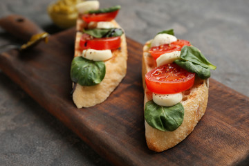 Fresh tasty bruschettas on wooden board, closeup