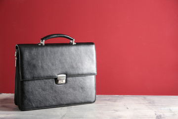Male briefcase on table against color background