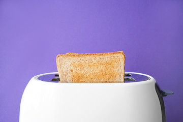 Slices of bread with toaster on color background