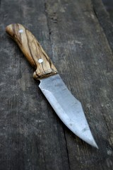 Beautiful homemade dangerous knife with a wooden handle lies on the table