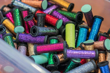 rolls with metallic threads in plastic container  in assortment for craft