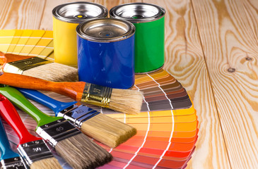 Painter and decorator work table with house project, color swatches, painting roller and paint...