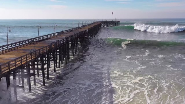 Aerial Over Huge Waves Rolling In Over A California Pier In Ventura California During A Big Winter Storm Suggests Global Warming And Sea Level Rise Or Tsunami.