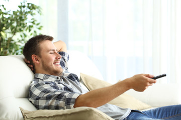 Happy man relaxing watching tv at home