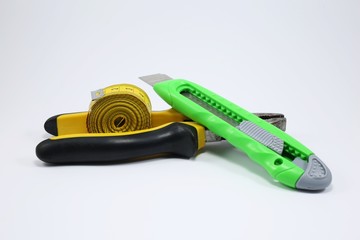 stationery knife and tape measure isolated on white background
