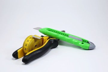 stationery knife and tape measure isolated on white background