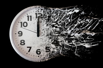 Time is running out concept shows clock that is dissolving away into little particles. Black and...