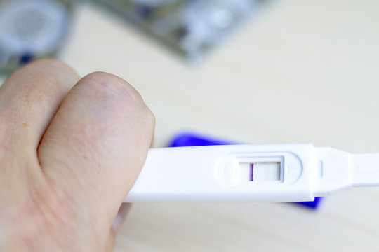 A man holds in his hand a pregnancy test with one strip. The concept of male impotence and infertility among men. Infertility in men.