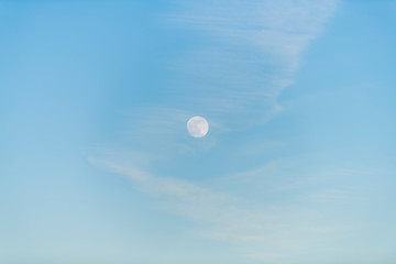 moon in a clear sky under a bright sun
