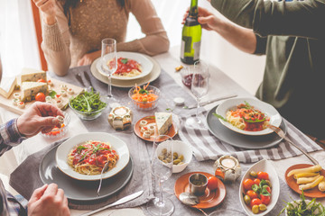 Friends having a pasta dinner at home of at a restaurant