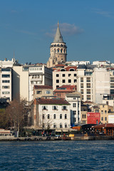 Galata Tower in Istanbul, Turkey. A view from water of Golden Horn bay. Sunny day. Outdoor shot