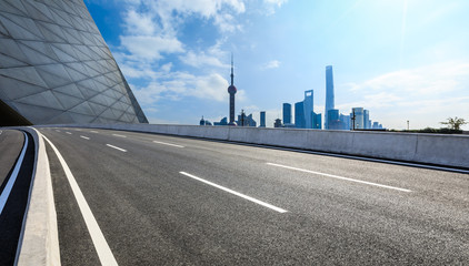Empty asphalt road and backlit city skyline in Shanghai,China