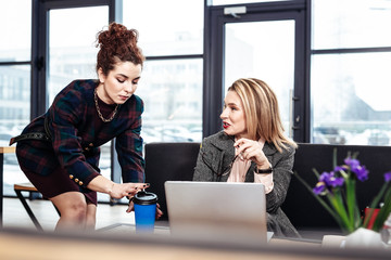 Blonde-haired female boss feeling thankful to her helpful secretary