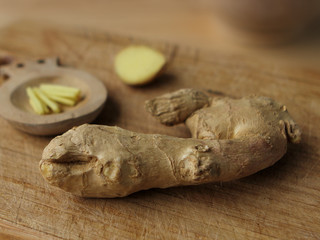 The ginger fruit is fresh, chopped finely, lies on a light wooden base, the concept of health and...