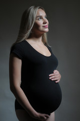 Studio portrait of a pregnant woman on dark background