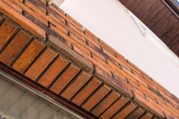 Worker putting red bricks on the house wall