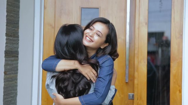 Concept of two girls who are greeting one and another in the front house