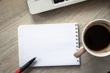 School notebook with pen, laptop and cup of coffee on wooden table with copy space