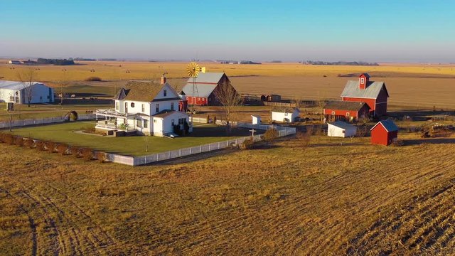 A drone aerial establishing shot over a classic beautiful farmhouse farm and barns in rural midwest America, York, Nebraska.
