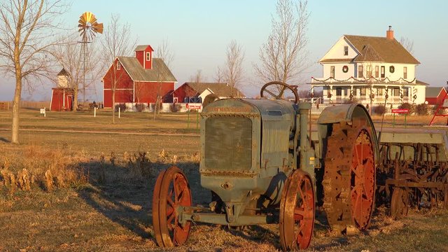 Establishing shot of a classic beautiful small town farmhouse farm, tractor and barns in rural midwest America, York, Nebraska.