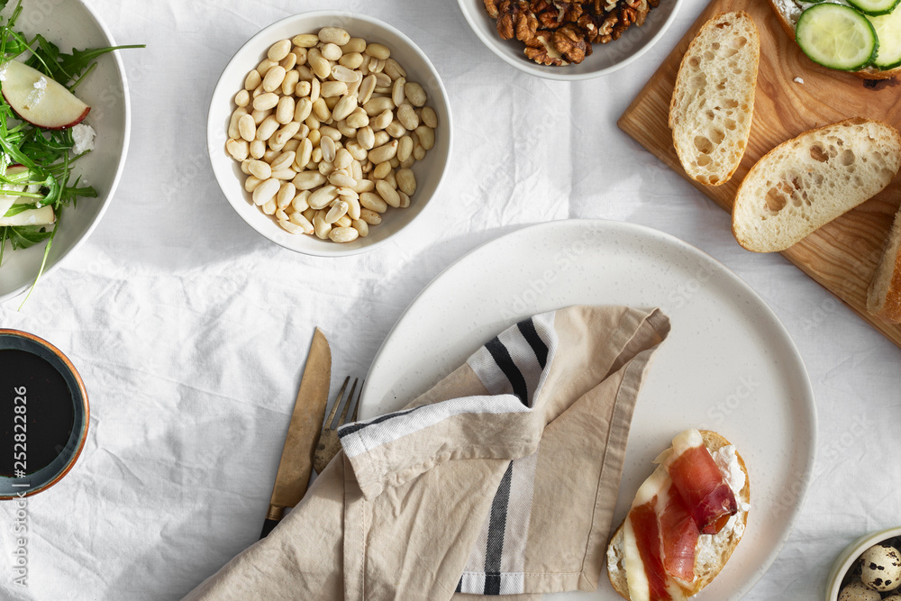 Wall mural Sandwiches prosciutto vegetables arugula salad light background top view Healthy breakfast snack