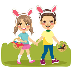 Adorable brother and sister children walking with easter eggs baskets and bunny ears holding hands