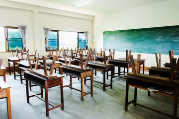 chair and table in class room with black board background, no student, school closed concept