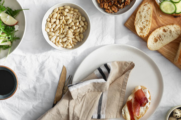 Sandwiches prosciutto vegetables arugula salad light background top view Healthy breakfast snack