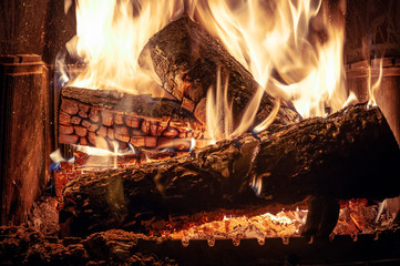 Fire burns in an indoor fireplace.