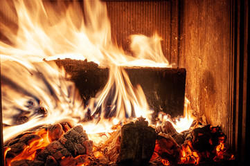 Fire burns in an indoor fireplace.