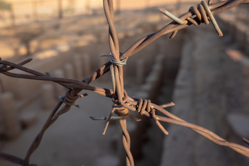 Close-up view of rusty barbed wire from a fence for an excavation field in Sudan