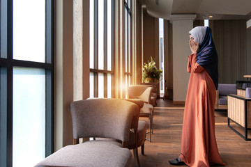 Muslim woman praying in public, concept religion of Islam