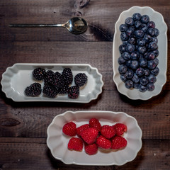 Blueberries, blackberries and raspberries on wooden background
