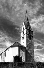small white European church in a Swiss alpine village in the Grisons