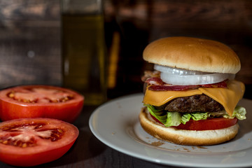 Sandwich with hamburger and tomatoes on wooden background