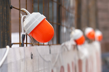 Orange warning lamps on the fencing protecting a repair site of the road on the moscow street