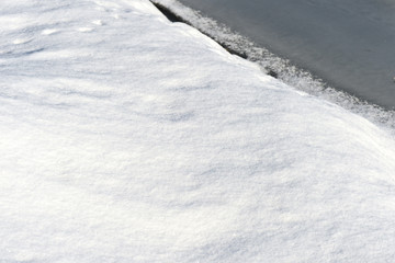 Snow and ice on a winter river. Winter texture and background